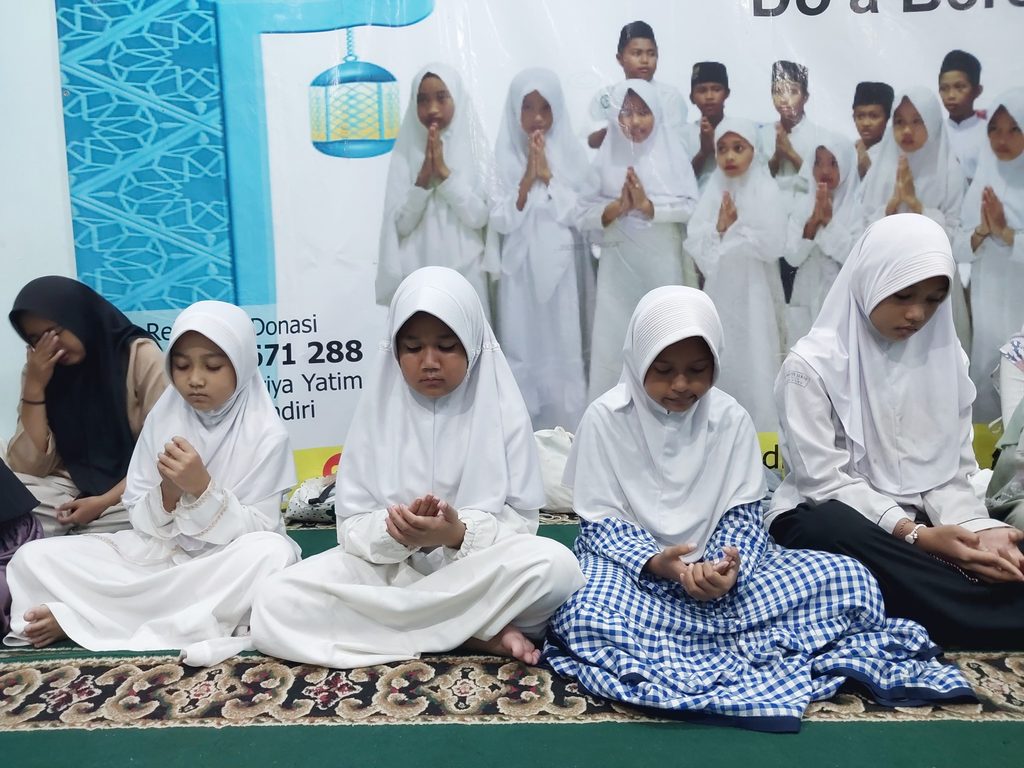 Anak-anak yatim dan dhuafa penerima santunan Maulid Nabi GYS tersenyum bahagia sambil memegang bingkisan gizi, alat sholat, dan uang tunai.