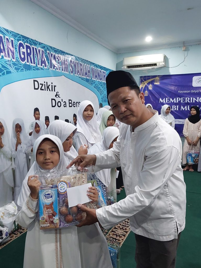 Anak-anak yatim dan dhuafa penerima santunan Maulid Nabi GYS tersenyum bahagia sambil memegang bingkisan gizi, alat sholat, dan uang tunai.