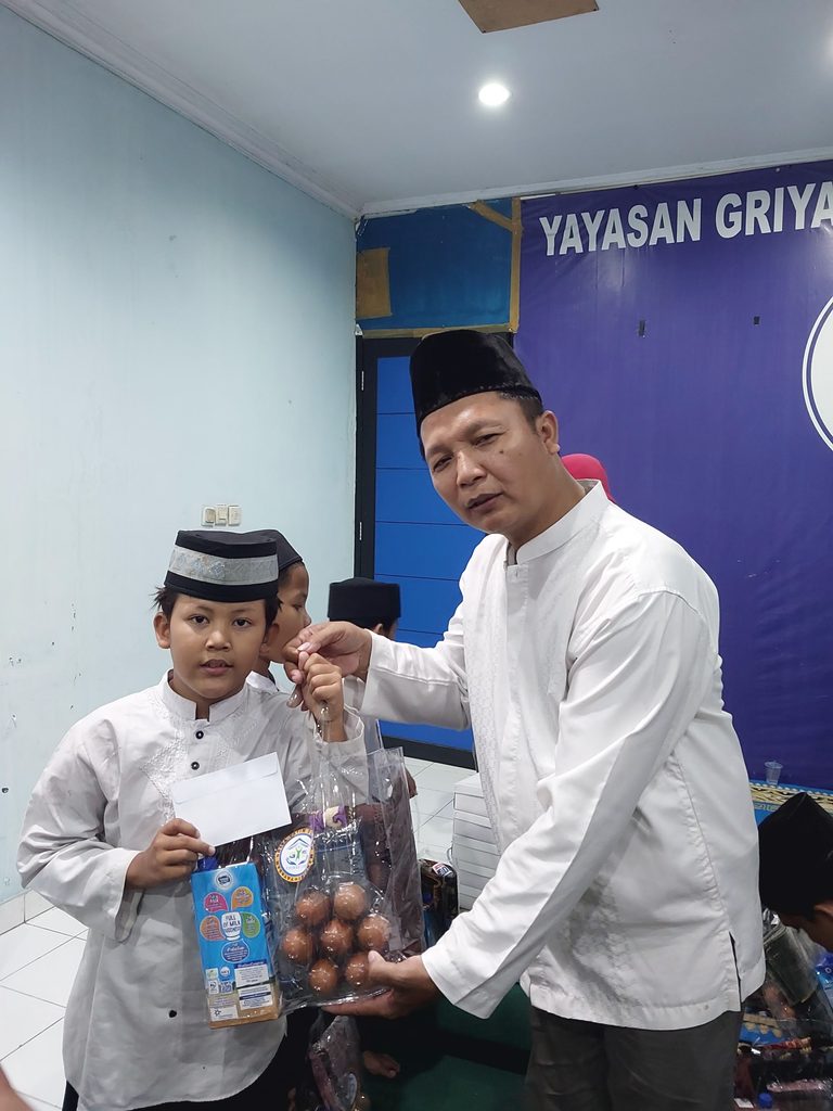 Anak-anak yatim dan dhuafa penerima santunan Maulid Nabi GYS tersenyum bahagia sambil memegang bingkisan gizi, alat sholat, dan uang tunai.