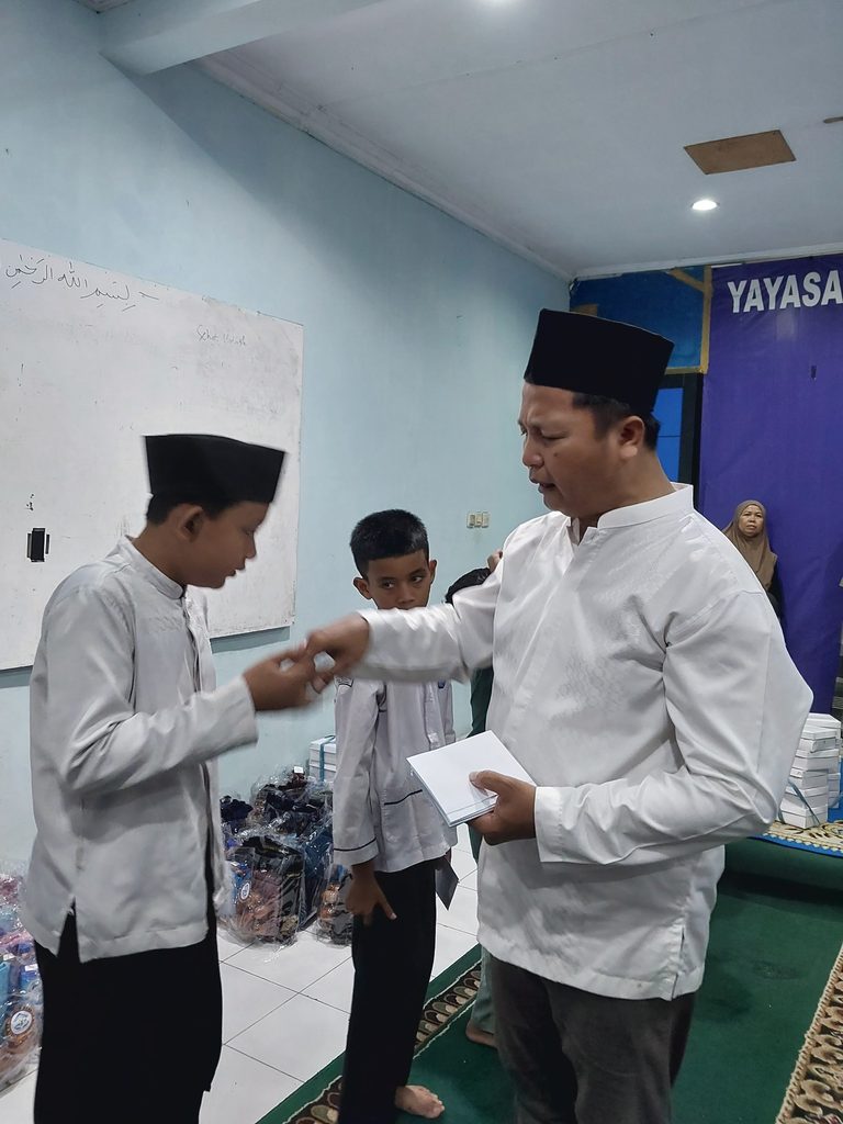Anak-anak yatim dan dhuafa penerima santunan Maulid Nabi GYS tersenyum bahagia sambil memegang bingkisan gizi, alat sholat, dan uang tunai.