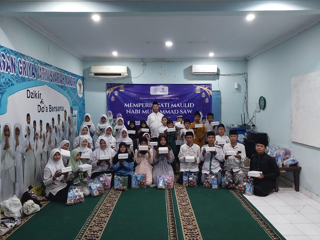 Anak-anak yatim dan dhuafa penerima santunan Maulid Nabi GYS tersenyum bahagia sambil memegang bingkisan gizi, alat sholat, dan uang tunai.